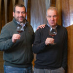 Portrait of two winemakers in a barrel cellar